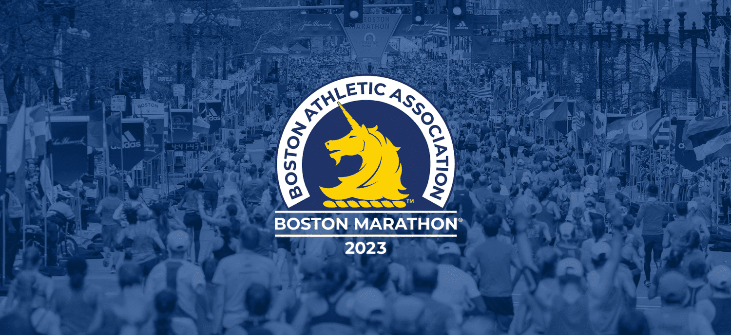 Runners crossing the finish line of the Boston Marathon 2023 with spectators cheering in the background.